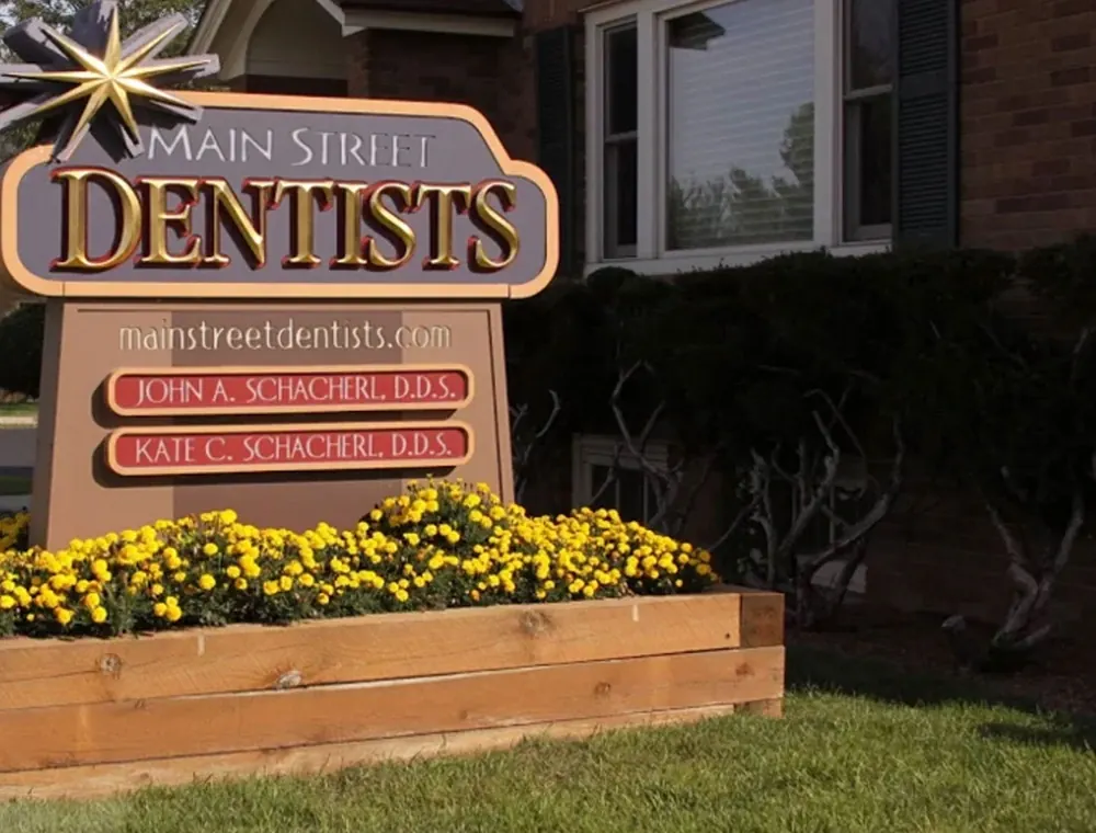 The Main Street Dentists sign outside the practice, naming Dr. John A. Schacherl and Dr. Kate C. Schacherl.